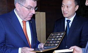 Bach, president of International Olympic Committee, receives the 120th anniversary of Olympics commemorative collection